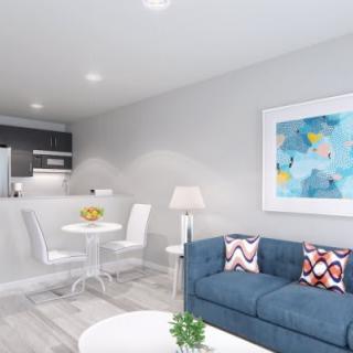 A modern living room with a cozy sofa, dining area, and contemporary artwork on the wall.