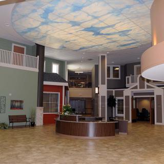 A modern reception area featuring a sky-themed ceiling and contemporary architectural design.