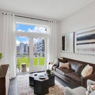 A modern living room with a view of the city, featuring stylish furniture and artwork.