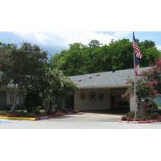 A suburban house with a neatly landscaped front yard and an American flag.