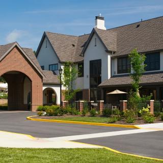 A charming residential building with a landscaped garden and driveway.