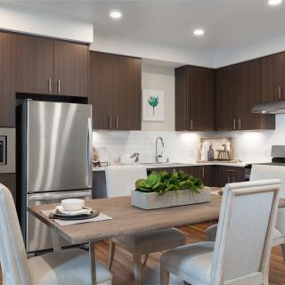 A modern kitchen with dark wood cabinets and stainless steel appliances, featuring a dining table with elegant chairs.