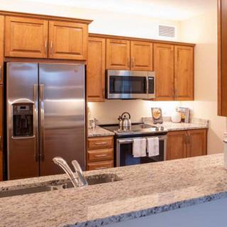 A modern kitchen with wood cabinets and stainless steel appliances.