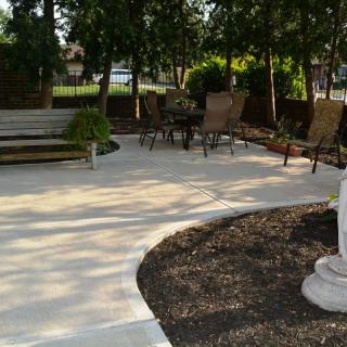 A serene outdoor patio area with seating surrounded by trees.