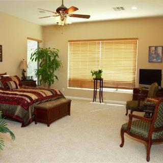 A cozy and well-decorated bedroom featuring a comfortable bed, stylish furniture, and ample natural light.