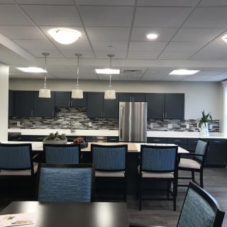 A modern kitchen interior with sleek cabinets, pendant lighting, and a central island.