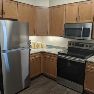 A modern kitchen featuring stainless steel appliances and wooden cabinets.