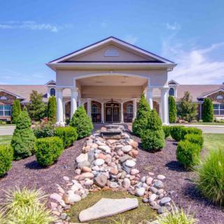 A well-landscaped building entrance on a sunny day.