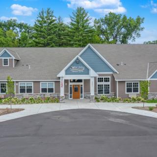 A modern, single-story building surrounded by trees and well-maintained landscaping.