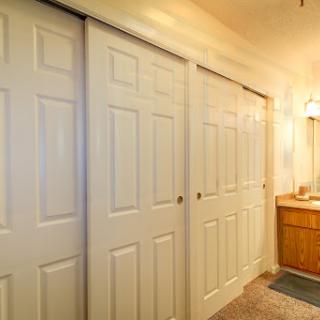 An interior view of a bathroom featuring sliding doors and a wooden vanity.