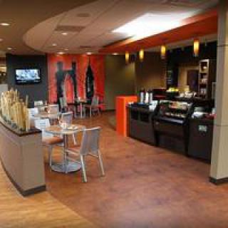Modern coffee shop interior with seating area and counter.