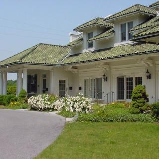 A beautiful residential house with well-maintained landscaping and a driveway.