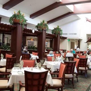 A spacious and elegantly decorated indoor restaurant with neatly arranged tables and chairs.