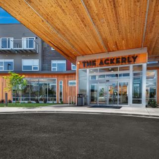 A modern building entrance with a wooden awning and glass windows.