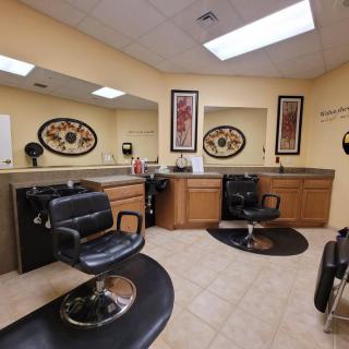 A cozy barber shop interior featuring two styling chairs and large mirrors.