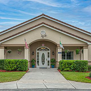 A symmetrical building entrance with flags and manicured landscaping.