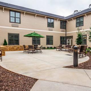 A spacious courtyard with tables, chairs, and an umbrella for outdoor relaxation.