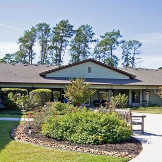 A single-story building with a landscaped garden and pathway.