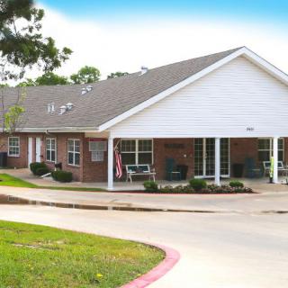 A suburban residential building with a covered porch and driveway.