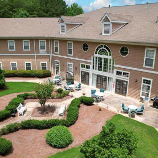 Aerial view of a building with a landscaped garden and outdoor seating area.