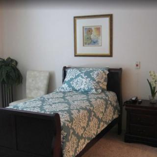 A neatly arranged bedroom with a single bed, a nightstand, and decorative elements.