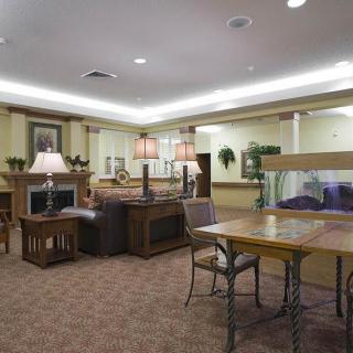 A cozy living room with comfortable seating, tables, and a fireplace.