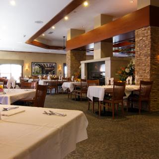A spacious and elegantly designed restaurant interior featuring well-set tables and a cozy atmosphere.