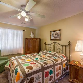 Cozy bedroom with a colorful quilt and classic furniture.