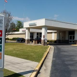 A healthcare facility viewed from a parking area.