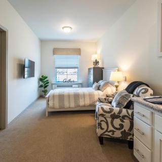 A cozy and well-designed bedroom with a bed, armchair, and stylish decor.