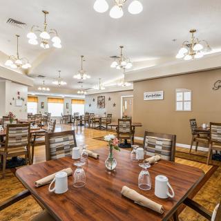 A well-lit dining area with neatly arranged tables and chairs in a restaurant setting.