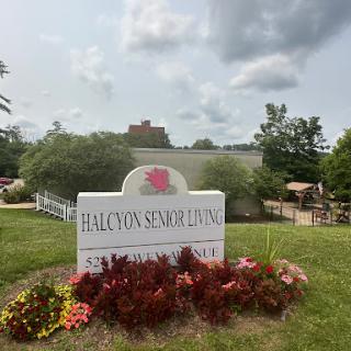 Welcome sign for Halcyon Senior Living, surrounded by vibrant landscaping.