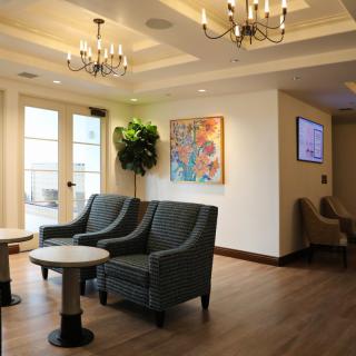 A modern lobby with comfortable seating, decorative chandeliers, and colorful artwork.