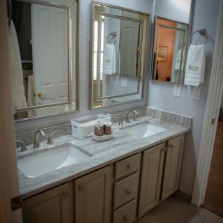 A stylish and modern bathroom vanity featuring dual sinks and elegant mirrors.