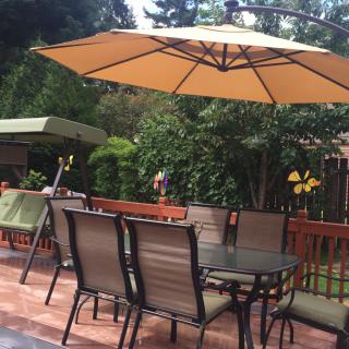 A cozy outdoor patio with a table and chairs under a large umbrella.