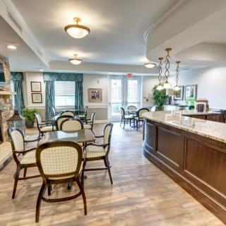 A well-lit dining area with tables and chairs, featuring elegant decor and spacious layout.