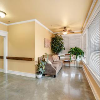 A serene waiting area featuring comfortable seating and plenty of natural light, enhanced by the presence of indoor plants.