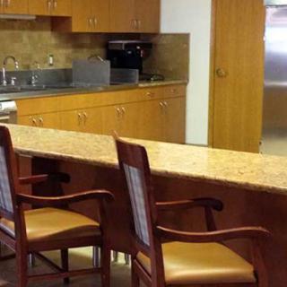 A kitchen area with a wooden countertop and chairs.
