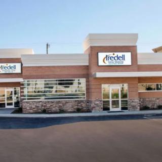 A commercial building with brick and stone accents featuring two retail storefronts.