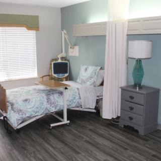 A hospital room with a patient bed, medical equipment, and modern interior decor.