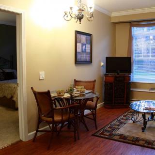 A cozy living area with a small dining table, TV, and warm lighting.