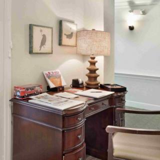 A cozy home office setup with a classic wooden desk and decorative elements.
