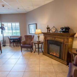 A cozy living room featuring a decorative fireplace, comfortable seating, and classic furnishings.