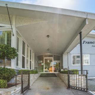 The inviting entrance of a modern building, featuring clean lines and well-maintained landscaping.