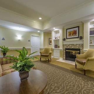 A cozy living room with comfortable seating, a fireplace, and decorative plants.