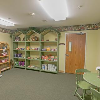 A cozy store interior with shelves displaying various products, accompanied by a table and chairs.