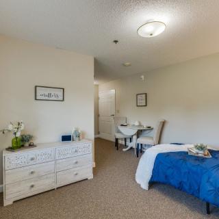 A neatly arranged bedroom featuring minimalist decor and a cozy ambiance.