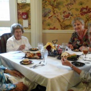 A group of elderly people enjoying a meal together at a restaurant.