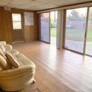 A spacious living room with hardwood floors, large sliding glass doors, and a comfortable sofa.