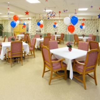 A decorated dining area with balloons and neatly arranged tables and chairs.